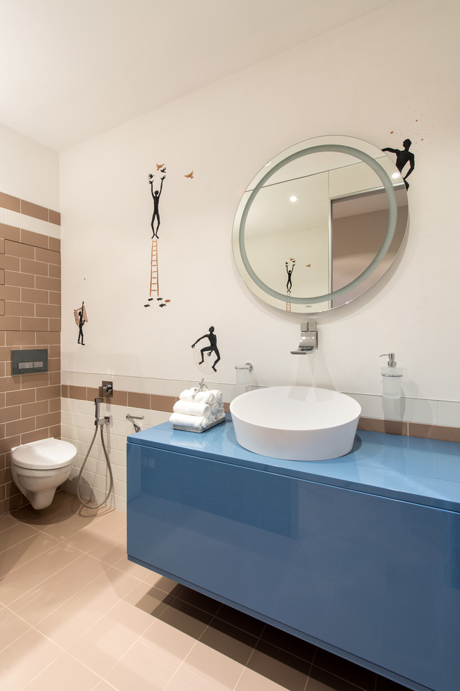 Idéer för att renovera ett mellanstort funkis blå blått badrum, med ett fristående handfat, släta luckor, blå skåp, en vägghängd toalettstol, brun kakel, vita väggar, bänkskiva i akrylsten, keramikplattor, klinkergolv i keramik och beiget golv