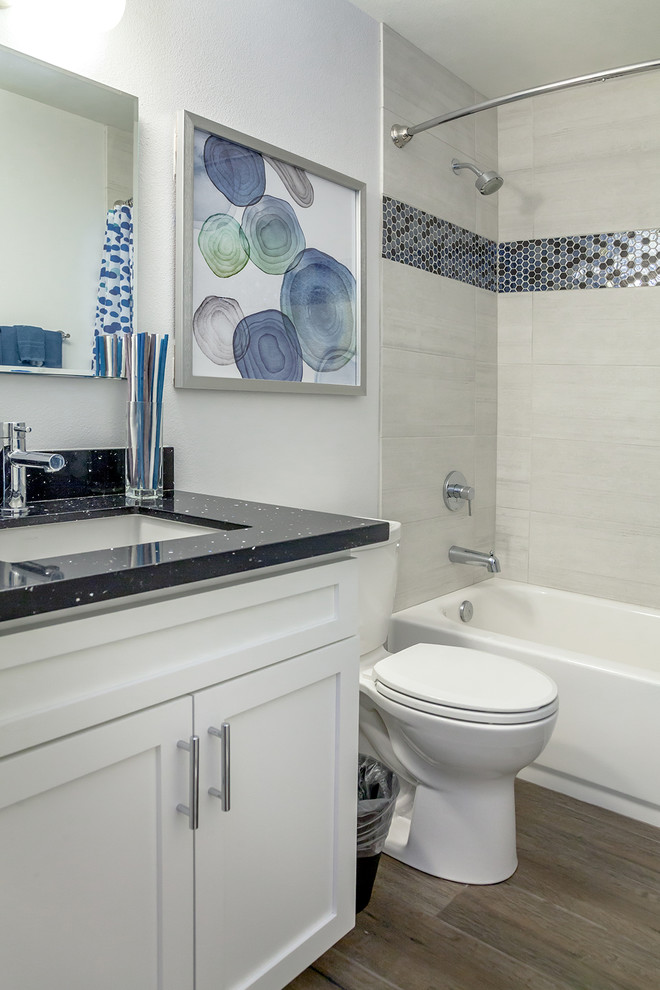 Bathroom - transitional kids' beige tile and porcelain tile porcelain tile and brown floor bathroom idea in Phoenix with recessed-panel cabinets, white cabinets, a one-piece toilet, white walls, an undermount sink and quartz countertops