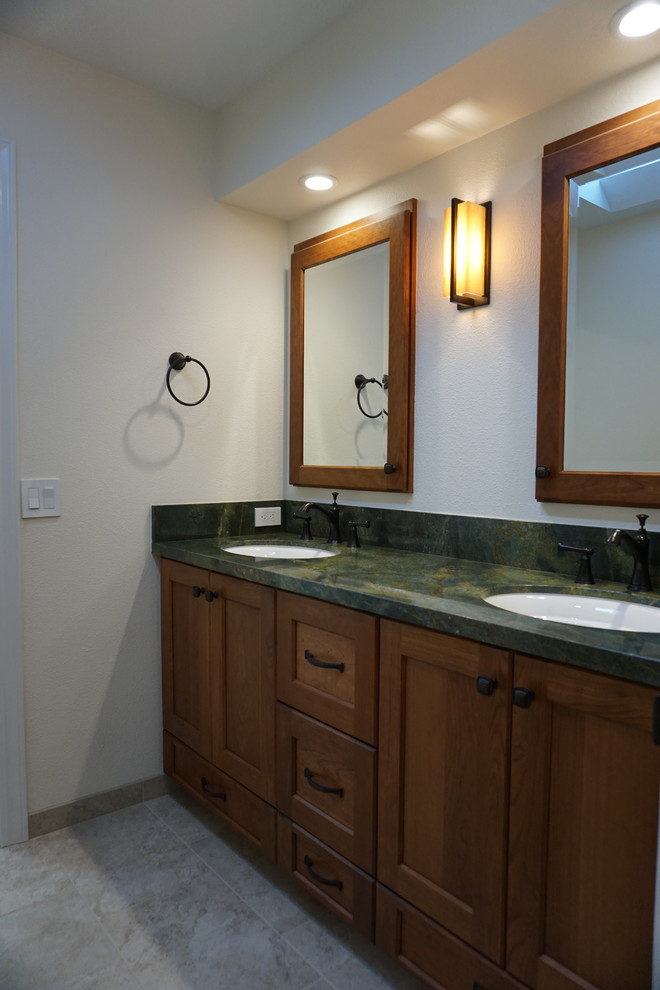 Example of a mid-sized arts and crafts kids' beige tile and porcelain tile porcelain tile and beige floor bathroom design in San Francisco with shaker cabinets, brown cabinets, a one-piece toilet, beige walls, an undermount sink, granite countertops and green countertops