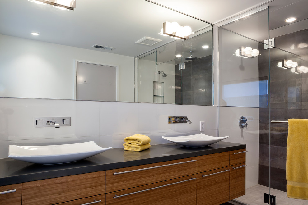 Inredning av ett modernt mellanstort en-suite badrum, med släta luckor, skåp i mellenmörkt trä, en dusch i en alkov, grå kakel, porslinskakel, vita väggar, klinkergolv i porslin, ett fristående handfat, bänkskiva i kvarts, grått golv och dusch med gångjärnsdörr