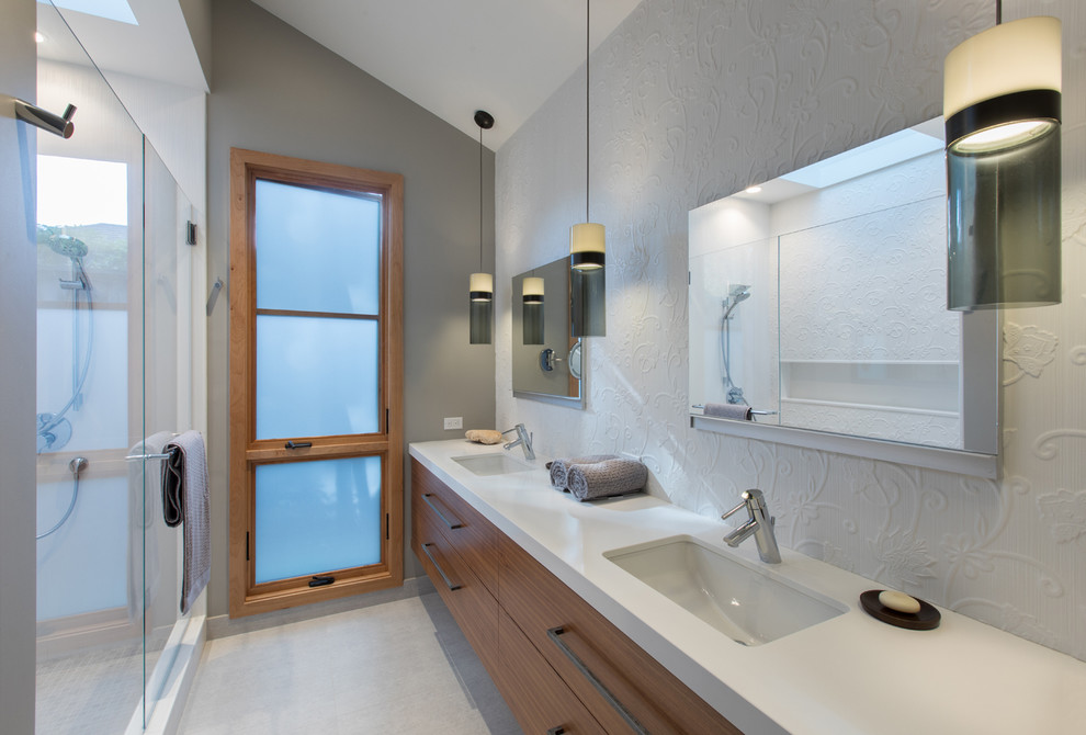 Inspiration for a large contemporary master white tile and porcelain tile porcelain tile alcove shower remodel in San Francisco with flat-panel cabinets, medium tone wood cabinets, white walls, an undermount sink and solid surface countertops