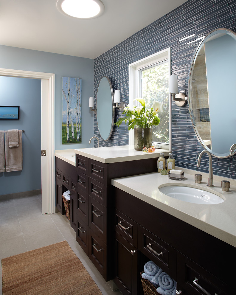 Mid-sized trendy master blue tile and ceramic tile slate floor and gray floor bathroom photo in San Francisco with shaker cabinets, dark wood cabinets, a two-piece toilet, blue walls, an undermount sink, solid surface countertops and a hinged shower door