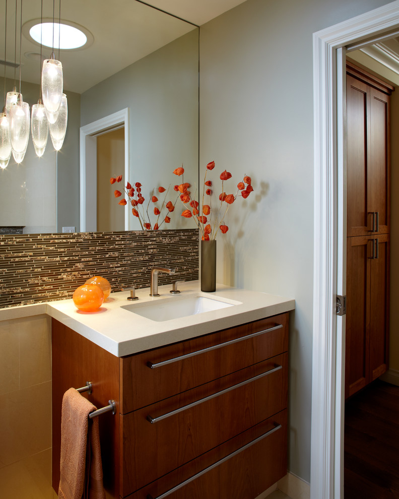 Example of a mid-sized trendy 3/4 brown tile and glass tile dark wood floor and brown floor bathroom design in San Francisco with flat-panel cabinets, dark wood cabinets, a one-piece toilet, gray walls, an integrated sink and solid surface countertops