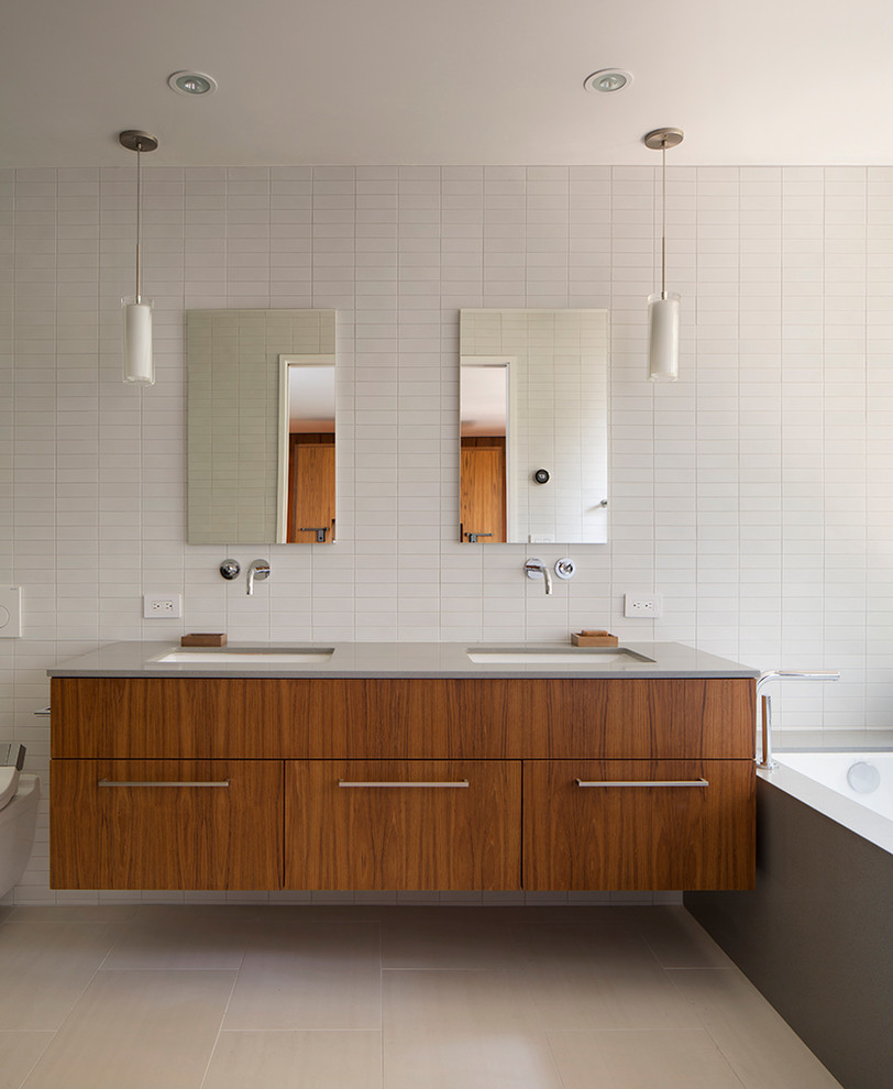 Modernes Badezimmer mit flächenbündigen Schrankfronten, hellbraunen Holzschränken, Unterbauwanne, Wandtoilette, weißer Wandfarbe und Unterbauwaschbecken in San Francisco