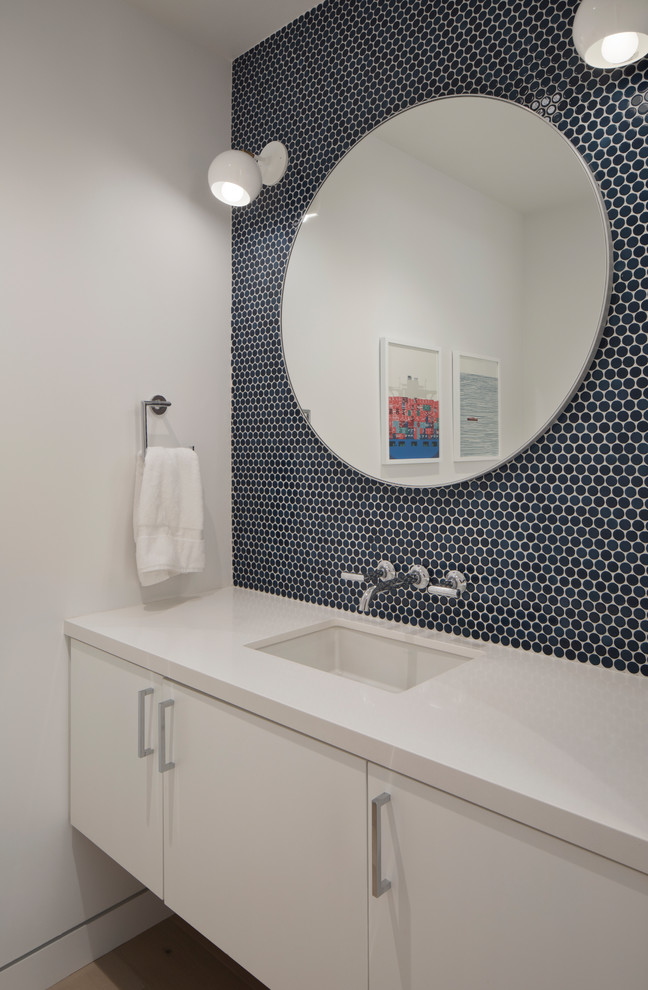 Idéer för funkis vitt badrum, med släta luckor, vita skåp, blå kakel, keramikplattor, vita väggar, ljust trägolv, ett undermonterad handfat och bänkskiva i kvarts