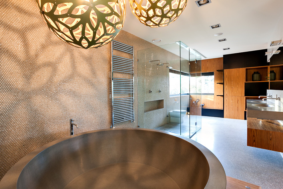 Immagine di una grande stanza da bagno contemporanea con lavabo integrato, vasca freestanding, doccia a filo pavimento, WC monopezzo, piastrelle beige, piastrelle a mosaico e pavimento in cemento