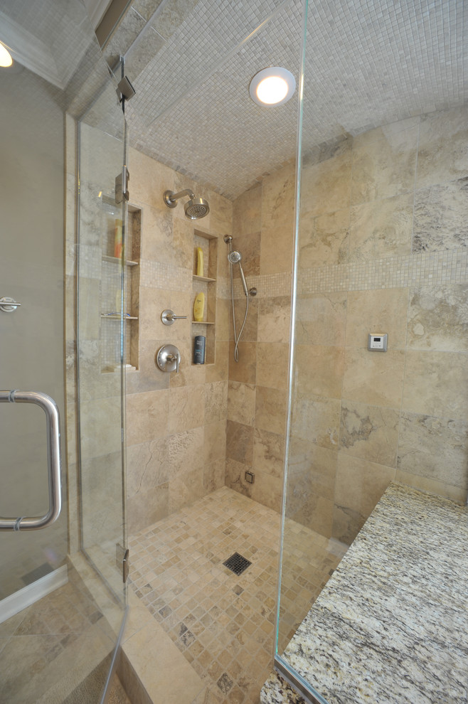 Klassisk inredning av ett stort badrum, med ett undermonterad handfat, luckor med infälld panel, skåp i mörkt trä, granitbänkskiva, ett undermonterat badkar, en dubbeldusch, en toalettstol med separat cisternkåpa och bruna väggar