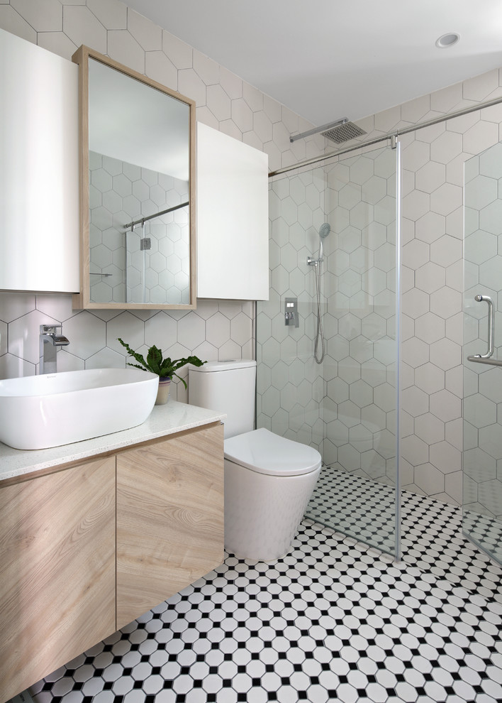 Стильный дизайн: ванная комната в скандинавском стиле с плоскими фасадами, светлыми деревянными фасадами, душем в нише, раздельным унитазом, бежевой плиткой, бежевыми стенами, душевой кабиной, настольной раковиной, разноцветным полом, душем с распашными дверями и белой столешницей - последний тренд