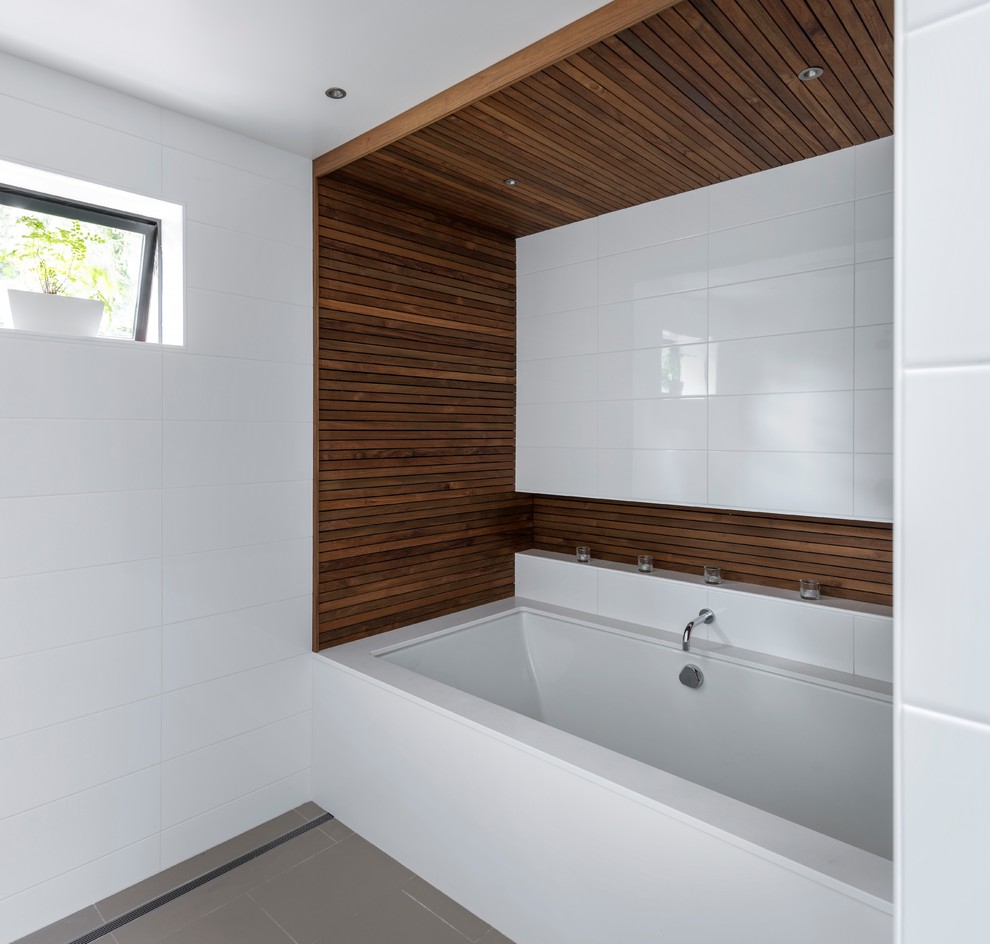 Пример оригинального дизайна: главная ванная комната среднего размера в современном стиле с полновстраиваемой ванной, белой плиткой, белыми стенами и серым полом