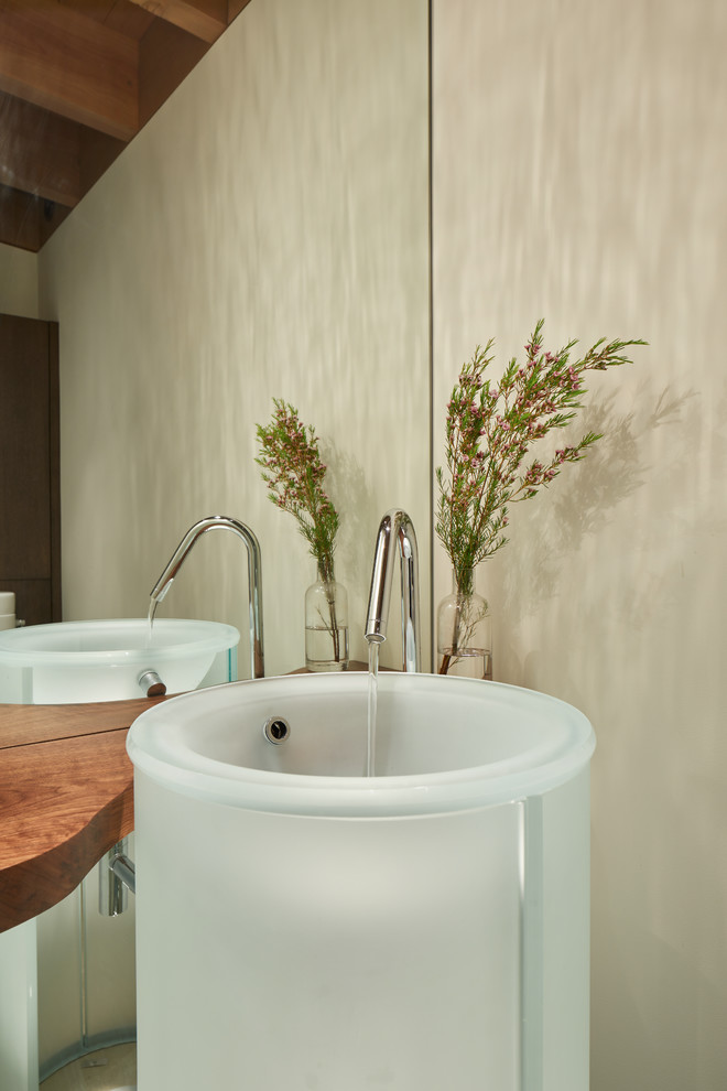 Пример оригинального дизайна: огромная ванная комната в стиле модернизм с белыми стенами, бетонным полом, раковиной с пьедесталом, столешницей из дерева, серым полом и коричневой столешницей