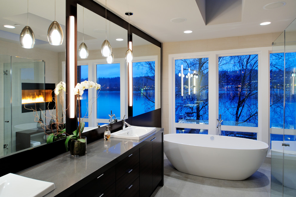 Großes Modernes Badezimmer En Suite mit flächenbündigen Schrankfronten, dunklen Holzschränken, freistehender Badewanne, Duschnische, beiger Wandfarbe und Mineralwerkstoff-Waschtisch in Seattle