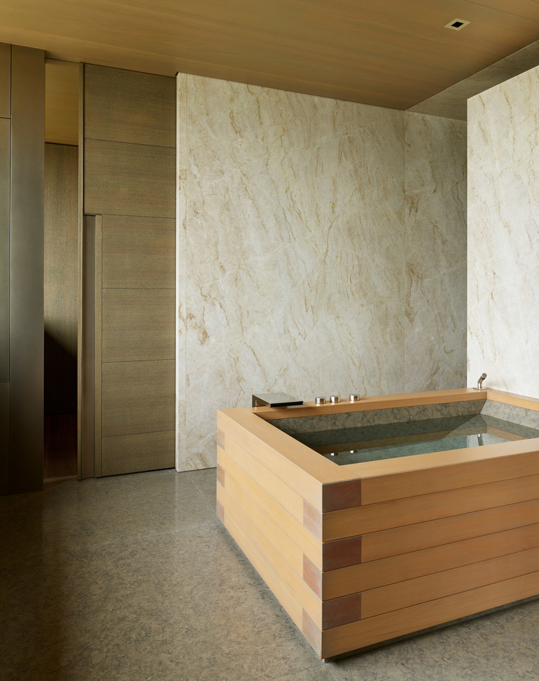 Modern inredning av ett badrum, med ett fristående badkar, vita väggar och grått golv