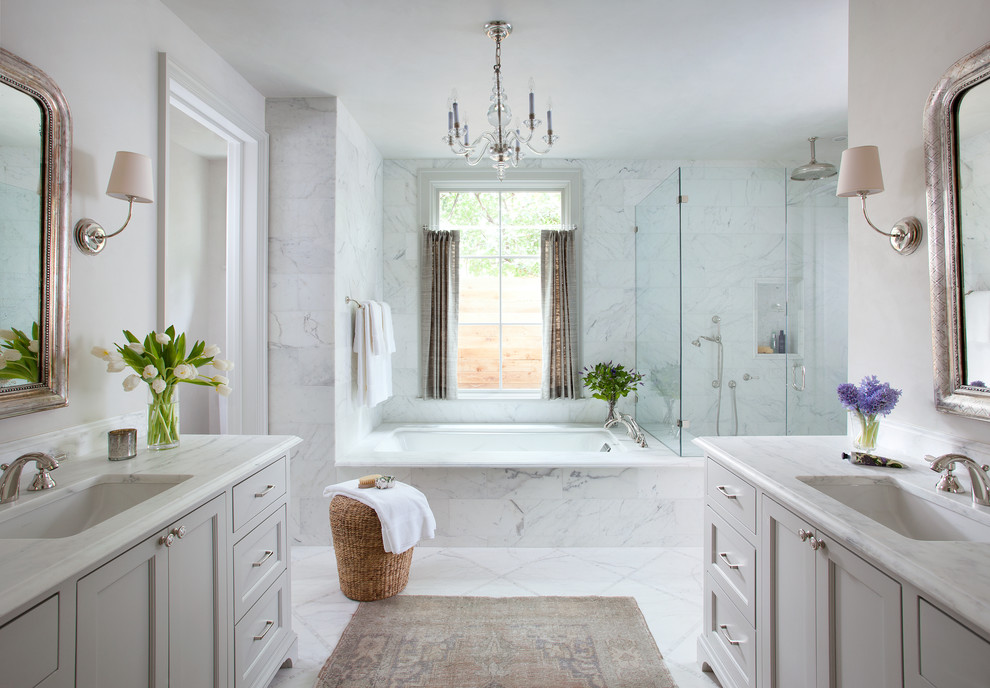 Идея дизайна: главная, серо-белая ванная комната в классическом стиле с врезной раковиной, фасадами в стиле шейкер, серыми фасадами, полновстраиваемой ванной, угловым душем, белой плиткой, серыми стенами, каменной плиткой и окном