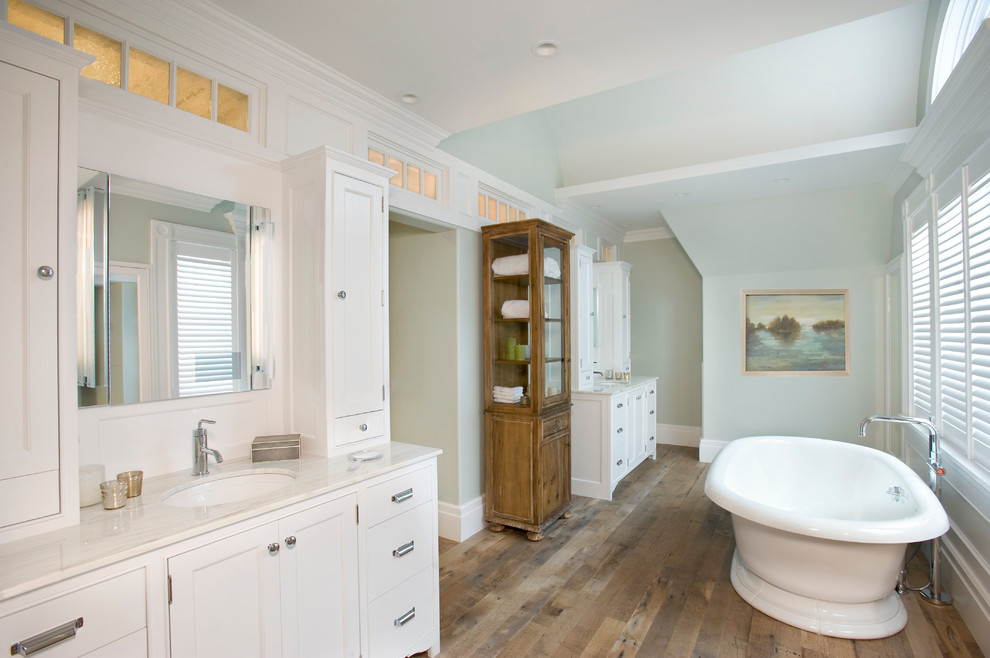 Bild på ett vintage badrum, med ett undermonterad handfat, skåp i shakerstil, vita skåp, ett fristående badkar, gröna väggar och mellanmörkt trägolv