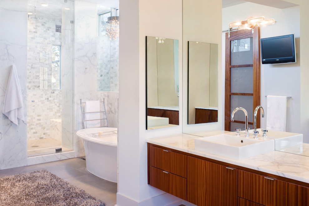 Пример оригинального дизайна: большая главная ванная комната в современном стиле с плоскими фасадами, фасадами цвета дерева среднего тона, отдельно стоящей ванной, душем в нише, белой плиткой, мраморной плиткой, белыми стенами, мраморным полом, настольной раковиной и мраморной столешницей