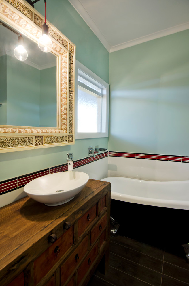 Exempel på ett litet eklektiskt en-suite badrum, med ett fristående handfat, möbel-liknande, skåp i mellenmörkt trä, träbänkskiva, ett badkar med tassar, en dusch i en alkov, en toalettstol med hel cisternkåpa, röd kakel, gröna väggar, klinkergolv i keramik, keramikplattor, brunt golv och dusch med gångjärnsdörr