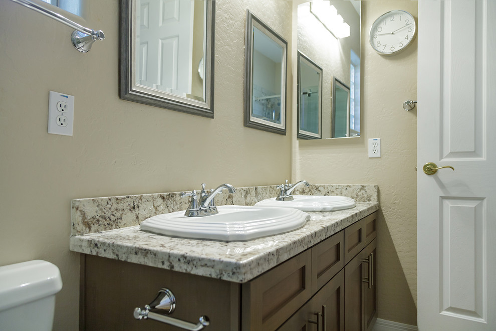 Bathroom - small transitional kids' beige tile and porcelain tile cement tile floor and brown floor bathroom idea in Phoenix with shaker cabinets, medium tone wood cabinets, a two-piece toilet, beige walls, a drop-in sink, granite countertops and beige countertops