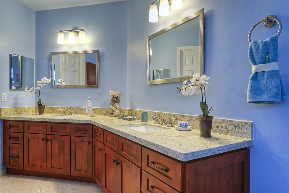 Esempio di una stanza da bagno padronale chic con lavabo da incasso, ante con bugna sagomata, ante in legno bruno, top in granito, pareti blu e pavimento con piastrelle in ceramica
