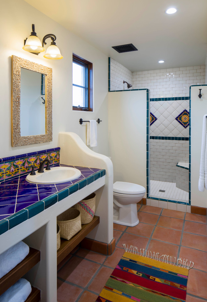 Inspiration för amerikanska flerfärgat badrum, med öppna hyllor, vita skåp, flerfärgad kakel, vita väggar, klinkergolv i terrakotta, kaklad bänkskiva, rött golv, en dusch i en alkov, en toalettstol med hel cisternkåpa, keramikplattor och med dusch som är öppen