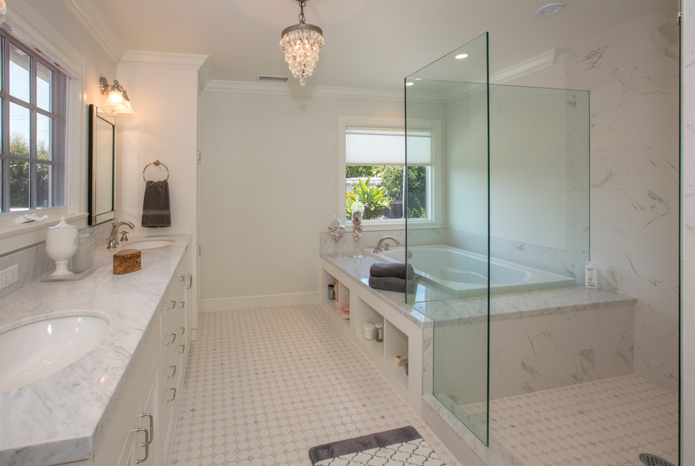 サンタバーバラにあるトランジショナルスタイルのおしゃれな浴室 (白いキャビネット、ドロップイン型浴槽、コーナー設置型シャワー、白いタイル、白い壁、アンダーカウンター洗面器) の写真
