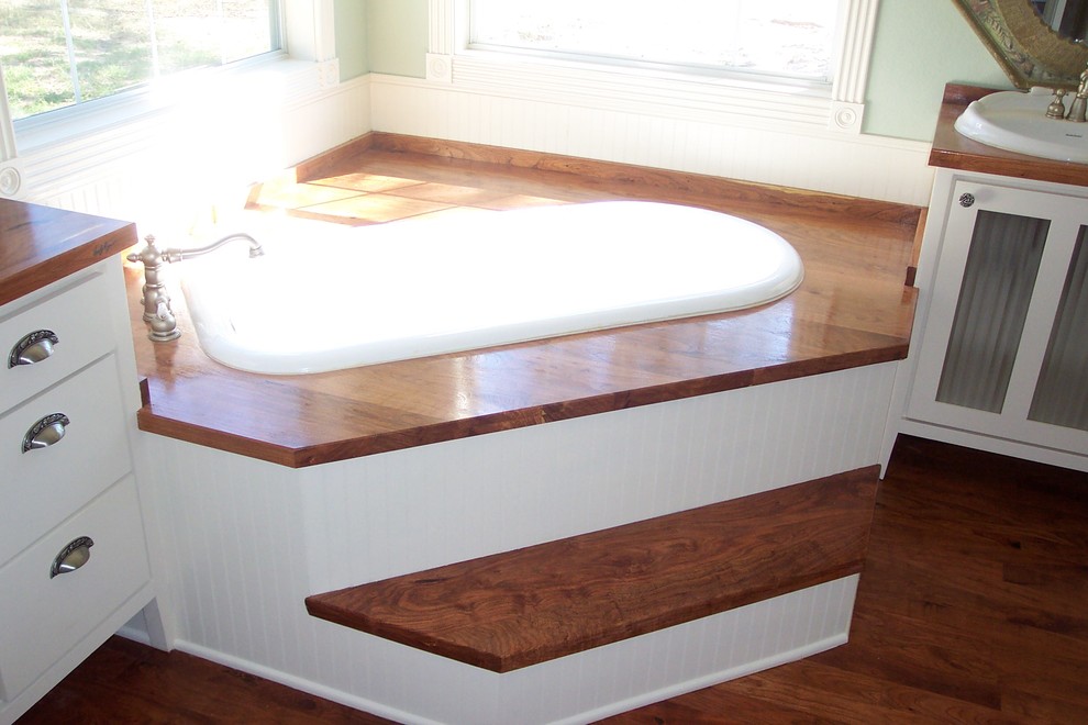 Réalisation d'une salle de bain tradition pour enfant avec un lavabo posé, un plan de toilette en bois, une baignoire sur pieds et parquet foncé.