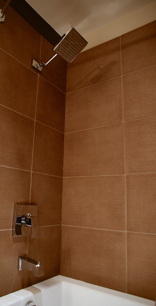 Aménagement d'une petite salle de bain contemporaine en bois brun avec une vasque, un placard en trompe-l'oeil, un plan de toilette en quartz modifié, une baignoire posée, un combiné douche/baignoire, WC à poser, un carrelage gris, des carreaux de porcelaine, un mur marron et un sol en carrelage de porcelaine.