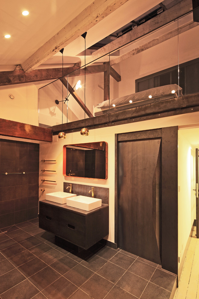 This is an example of a contemporary bathroom in London with a built-in sink, dark wood cabinets, black tiles, ceramic tiles, beige walls and ceramic flooring.