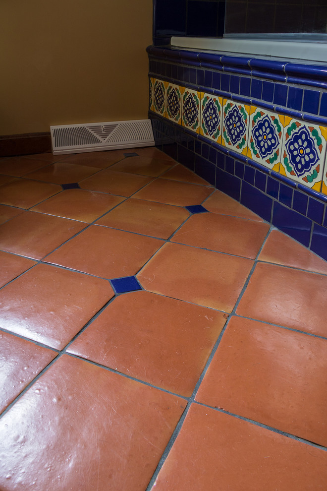 Immagine di una stanza da bagno con doccia stile americano di medie dimensioni con ante in stile shaker, ante in legno scuro, piastrelle blu, piastrelle in ceramica, lavabo da incasso e top piastrellato