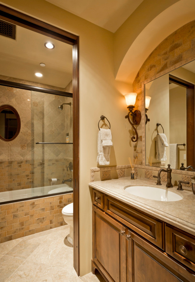 Exemple d'une très grande salle de bain principale sud-ouest américain en bois brun avec une baignoire posée, un carrelage beige, un mur beige, un placard à porte plane, un combiné douche/baignoire, WC séparés, mosaïque, un sol en travertin, un lavabo intégré et un plan de toilette en granite.
