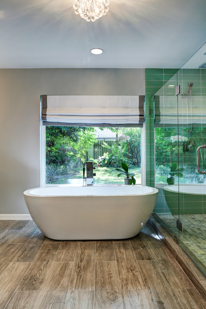 This is an example of a medium sized contemporary ensuite bathroom in Houston with a freestanding bath, a double shower, green tiles, glass tiles, a submerged sink, flat-panel cabinets, grey cabinets, engineered stone worktops, a one-piece toilet, white walls and dark hardwood flooring.