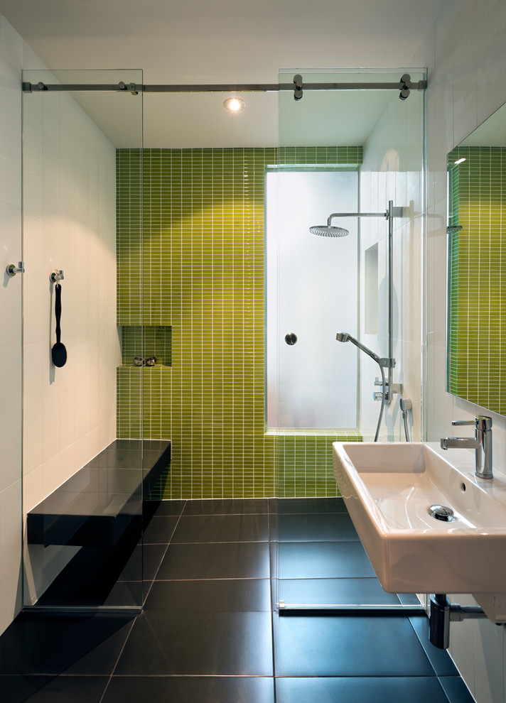 Inredning av ett modernt mellanstort en-suite badrum, med en kantlös dusch, grön kakel, mosaik, vita väggar, klinkergolv i porslin, ett väggmonterat handfat, svart golv och dusch med skjutdörr