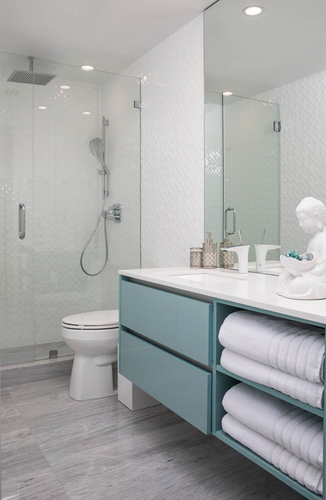 Foto på ett mellanstort funkis vit badrum för barn, med släta luckor, keramikplattor, marmorgolv, bänkskiva i kvarts, blå skåp, en dusch i en alkov, vit kakel, ett undermonterad handfat och grått golv