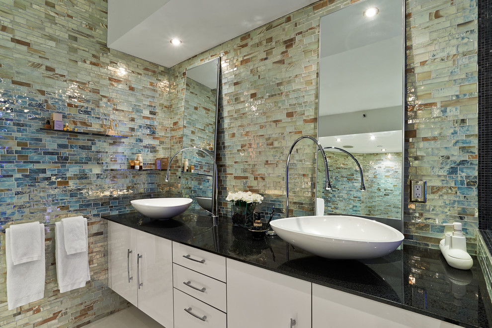 Diseño de cuarto de baño moderno de tamaño medio con lavabo sobreencimera, ducha esquinera y baldosas y/o azulejos en mosaico