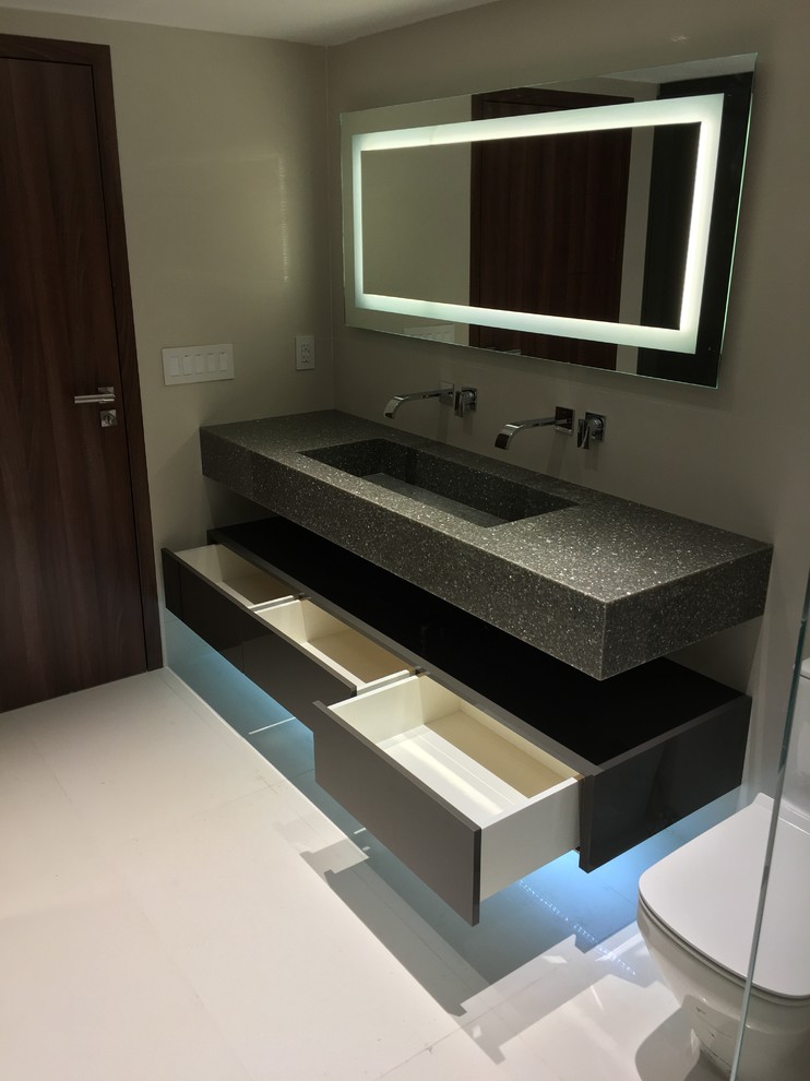 Inredning av ett modernt mellanstort en-suite badrum, med öppna hyllor, bruna skåp, en toalettstol med hel cisternkåpa, beige väggar, ett avlångt handfat och granitbänkskiva