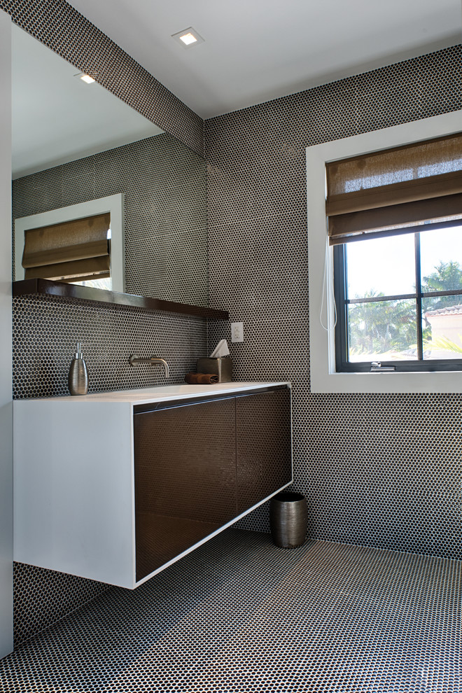 На фото: ванная комната в современном стиле с монолитной раковиной, плоскими фасадами, коричневой плиткой, темными деревянными фасадами и окном