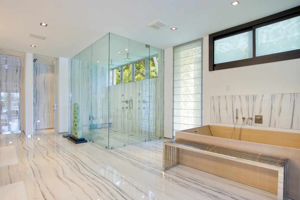 Пример оригинального дизайна: главная ванная комната в современном стиле с отдельно стоящей ванной, двойным душем, белой плиткой и белыми стенами