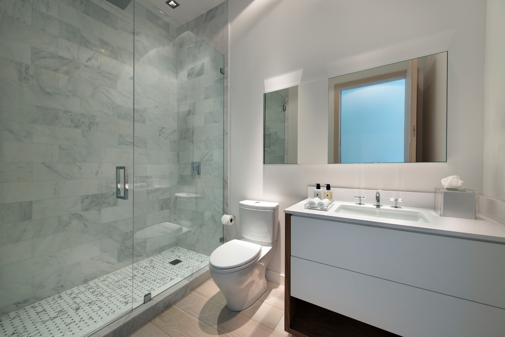 This is an example of a large contemporary shower room bathroom in Miami with a submerged sink, light wood cabinets, engineered stone worktops, a one-piece toilet, grey tiles, stone tiles, white walls and light hardwood flooring.