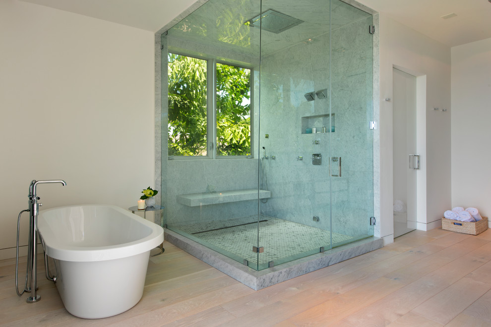 Cette image montre une grande salle de bain principale design en bois clair avec un lavabo encastré, un plan de toilette en quartz modifié, une baignoire indépendante, WC à poser, un carrelage gris, des dalles de pierre, un mur blanc et parquet clair.