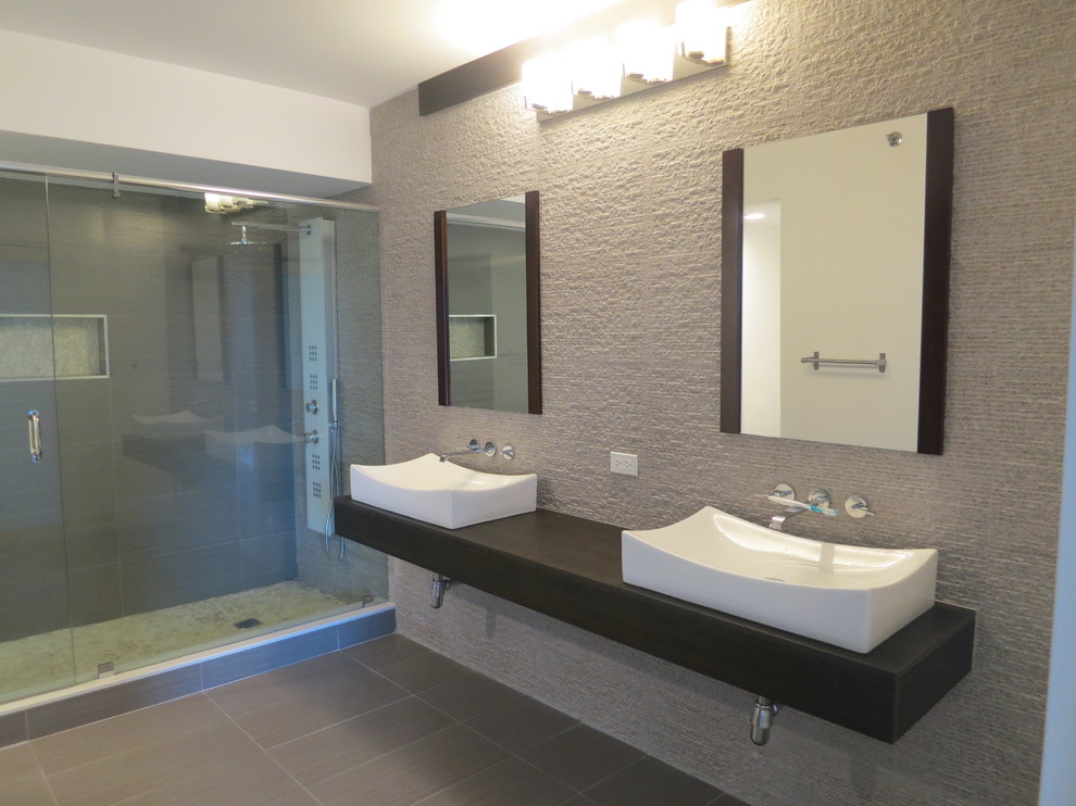 Großes Modernes Badezimmer En Suite mit dunklen Holzschränken, Laminat-Waschtisch, Doppeldusche, grauen Fliesen und Keramikboden in Miami