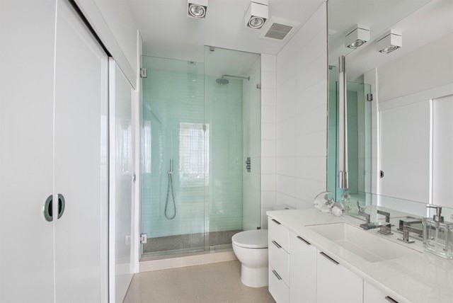 Exempel på ett mellanstort modernt badrum med dusch, med släta luckor, vita skåp, en dusch i en alkov, porslinskakel, vita väggar, klinkergolv i porslin, ett undermonterad handfat och bänkskiva i kvarts