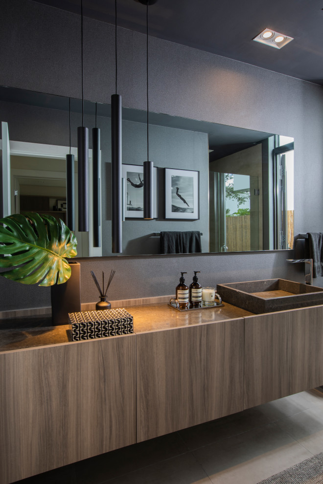 Modernes Badezimmer mit flächenbündigen Schrankfronten, hellbraunen Holzschränken, grauer Wandfarbe, Aufsatzwaschbecken, grauem Boden, grauer Waschtischplatte, Einzelwaschbecken und schwebendem Waschtisch in Miami