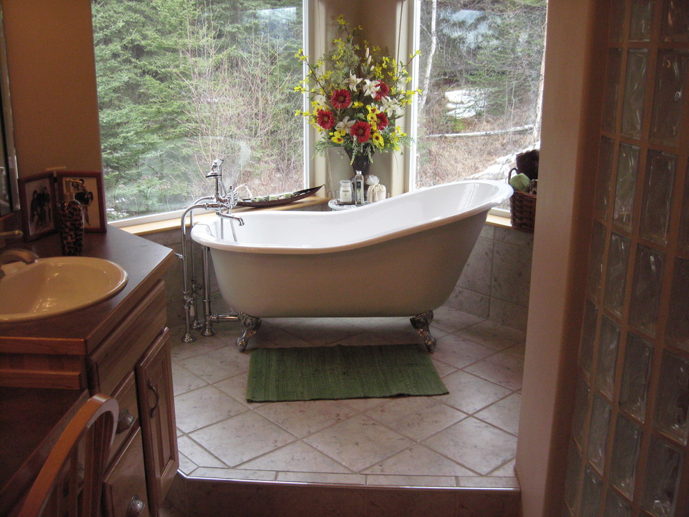 Exemple d'une salle de bain principale tendance en bois clair de taille moyenne avec un placard avec porte à panneau surélevé, une baignoire sur pieds, un mur blanc, un sol en carrelage de céramique, un lavabo posé et un plan de toilette en bois.
