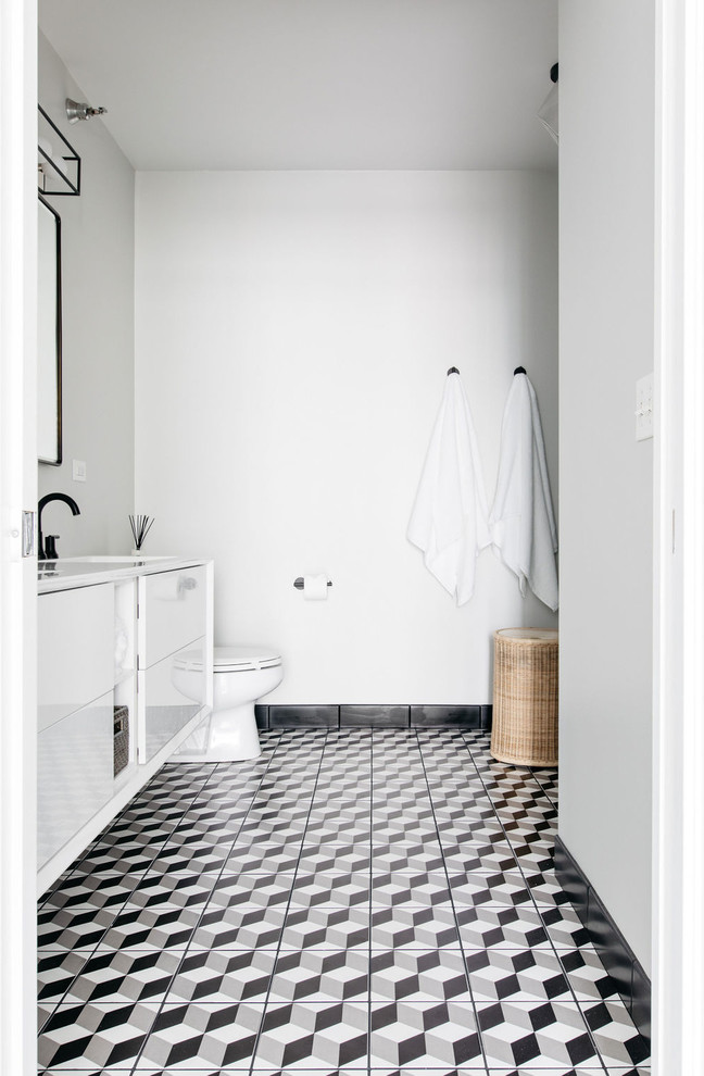 Idéer för mellanstora funkis vitt en-suite badrum, med släta luckor, vita skåp, ett platsbyggt badkar, våtrum, en toalettstol med separat cisternkåpa, vit kakel, tunnelbanekakel, grå väggar, klinkergolv i porslin, ett integrerad handfat, bänkskiva i akrylsten, svart golv och dusch med gångjärnsdörr