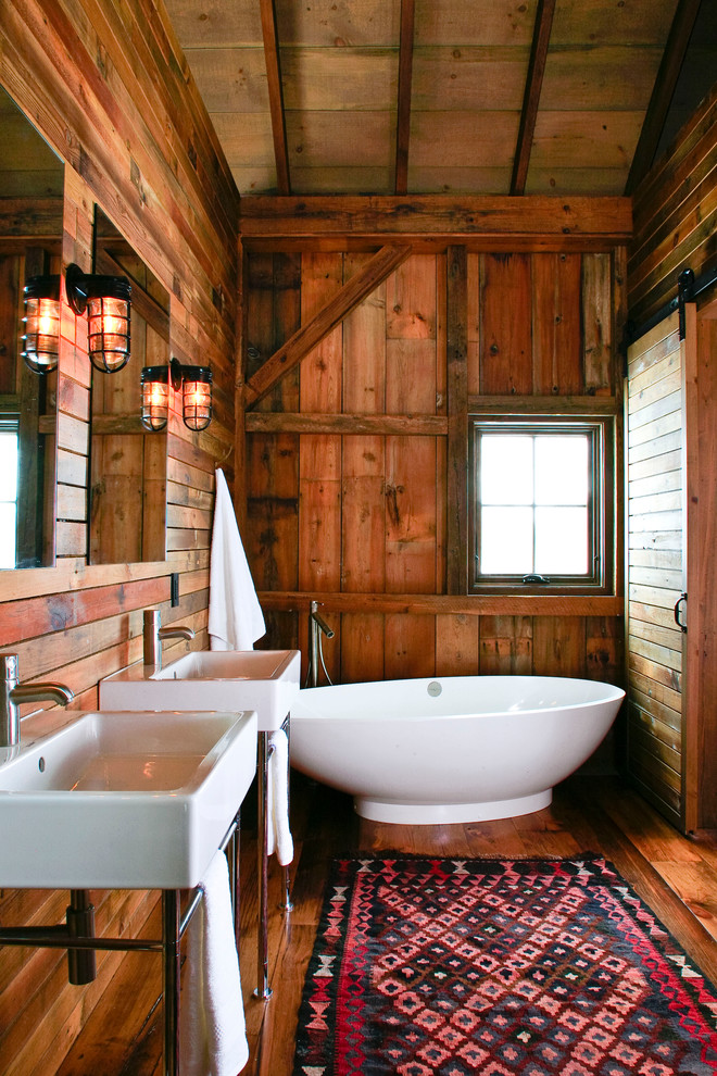 Exempel på ett rustikt badrum, med ett fristående badkar och ett konsol handfat