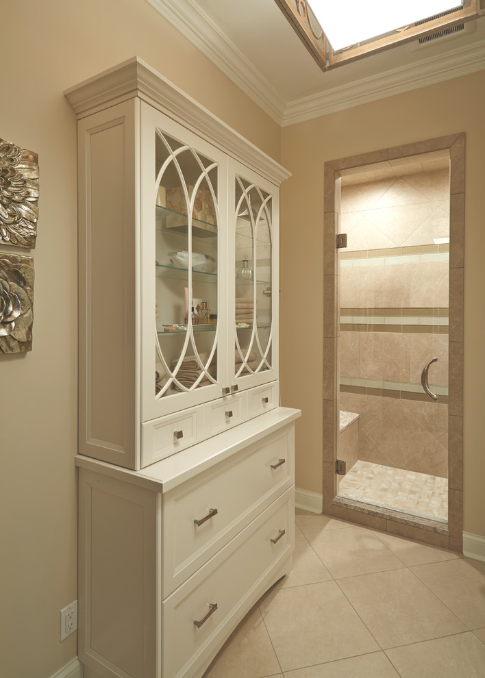 Classic ensuite bathroom in Chicago with shaker cabinets, white cabinets, a freestanding bath, an alcove shower, a two-piece toilet, beige tiles, ceramic tiles, beige walls, ceramic flooring, a submerged sink and limestone worktops.