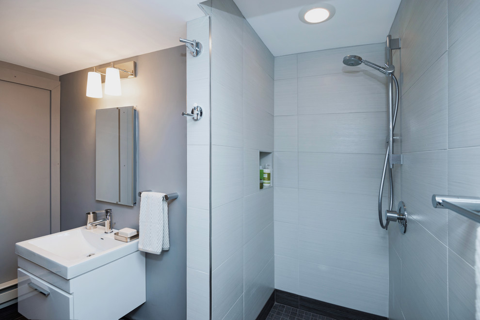 Foto på ett litet funkis badrum med dusch, med ett väggmonterat handfat, släta luckor, vita skåp, en dusch i en alkov, en toalettstol med separat cisternkåpa, gul kakel, porslinskakel, grå väggar och klinkergolv i porslin
