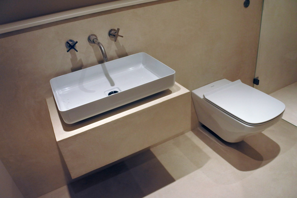 Cette image montre une petite salle de bain principale méditerranéenne avec un placard en trompe-l'oeil, une douche ouverte, sol en béton ciré, un sol beige et une cabine de douche à porte battante.