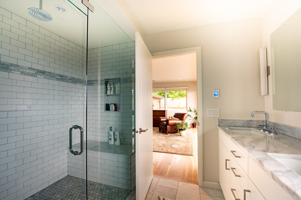 Idéer för mellanstora vintage grått en-suite badrum, med släta luckor, vita skåp, en dusch i en alkov, vit kakel, tunnelbanekakel, vita väggar, marmorgolv, ett undermonterad handfat, granitbänkskiva, grått golv och dusch med gångjärnsdörr