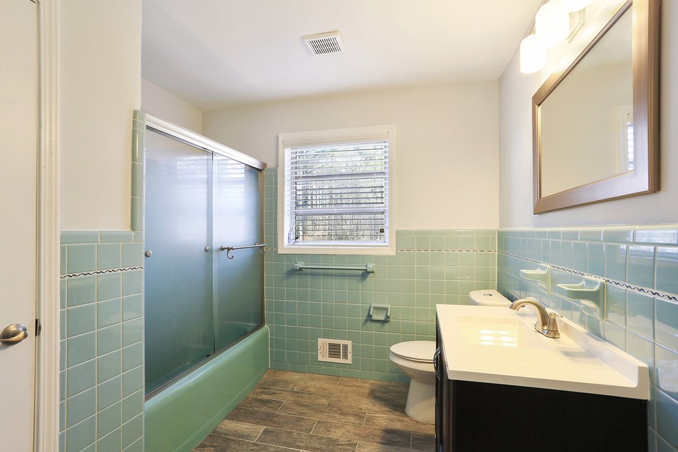 Exempel på ett mellanstort 50 tals badrum för barn, med möbel-liknande, skåp i mellenmörkt trä, ett platsbyggt badkar, grön kakel, keramikplattor, grå väggar, klinkergolv i porslin och bänkskiva i täljsten
