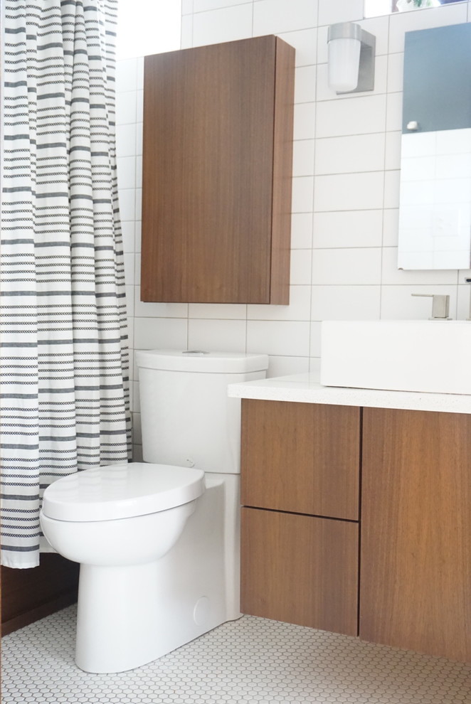 Example of a mid-century modern white tile bathroom design in St Louis with flat-panel cabinets, medium tone wood cabinets, a vessel sink, quartz countertops and white countertops